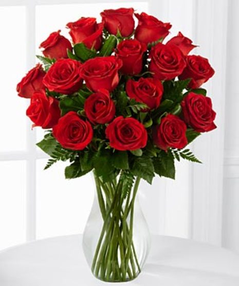 One dozen red roses in glass vase