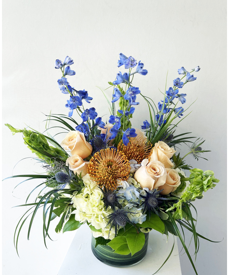 beachside floral arrangement with blues, creams, and white flowers