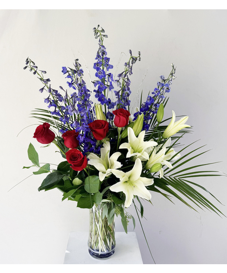 blue and white floral arrangement with delphinium and lilies