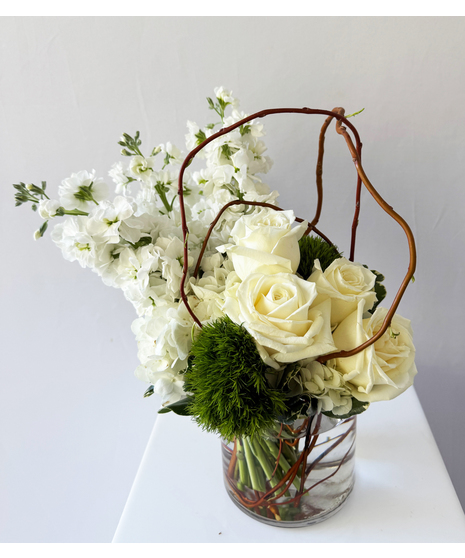 A refreshing touch of green nestled next to cream roses, large, white hydrangea and fragrant stock blooms. 