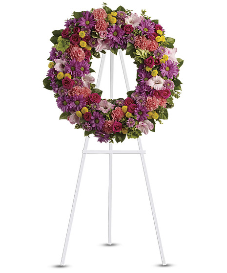 Heart-shaped sympathy wreath of yellow and white blossoms.