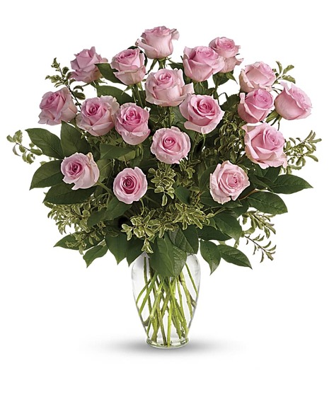 One dozen pink roses in a clear glass vase. 