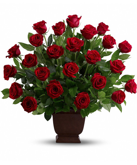 Two dozen red roses in a white sympathy urn with accent flowers. 