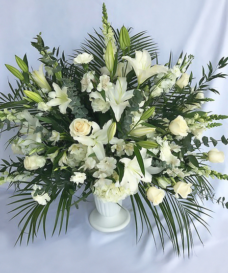 All-white sympathy arrangement presented in a white urn. 