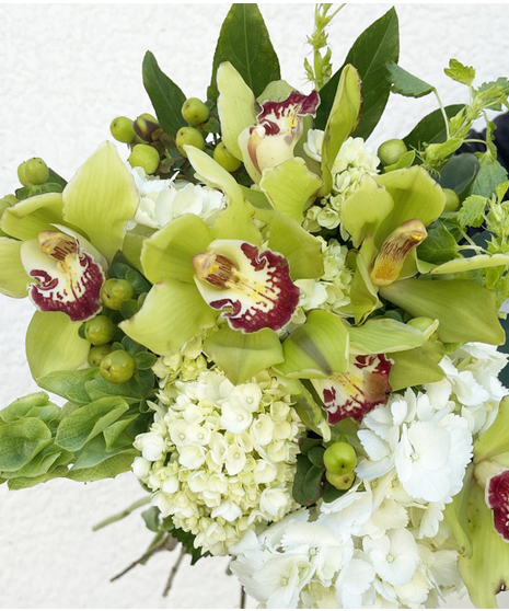 Closeup of green carnations and white lilies and daisies.