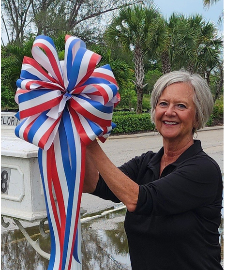 Nancy holding large red, white, and blue ribbon