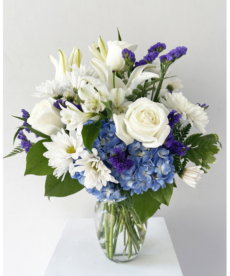 Blue and white flowers in a cobalt blue glass vase. 