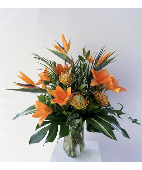 vibrant orange flowers n tropical arrangement accented with periwinkle blue accents
